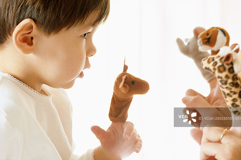 玩偶戏的小男孩（2-4岁），侧面视角图片素材