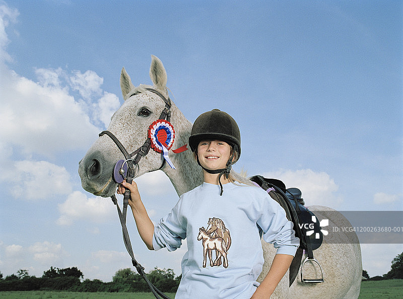 微笑的女孩（10-12岁）手持马笼头的肖像图片素材