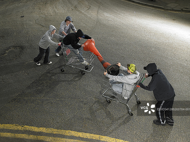 一群青少年男孩（13-15岁）在购物车里打闹图片素材