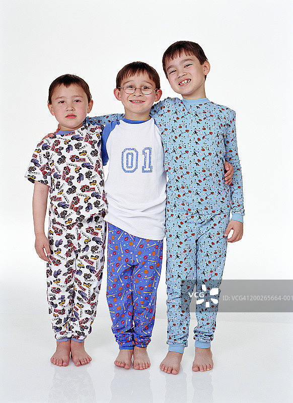 三个兄弟（5-8岁）肩并肩站成一排，面带微笑图片素材