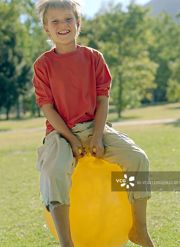 在充气跳跳马上玩耍的男孩（9-11岁）肖像图片素材