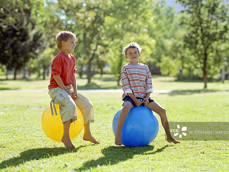 两个男孩在充气跳跳马上玩耍图片素材
