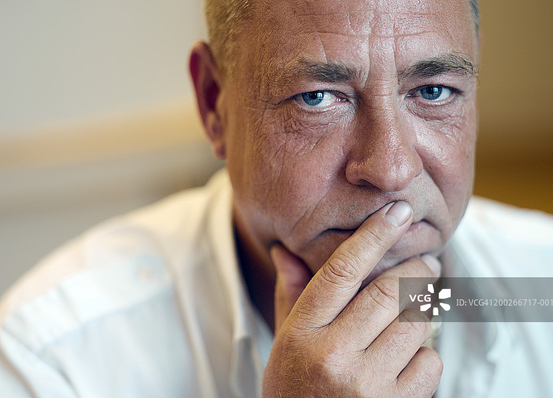 手放在嘴上的中年男人肖像特写图片素材