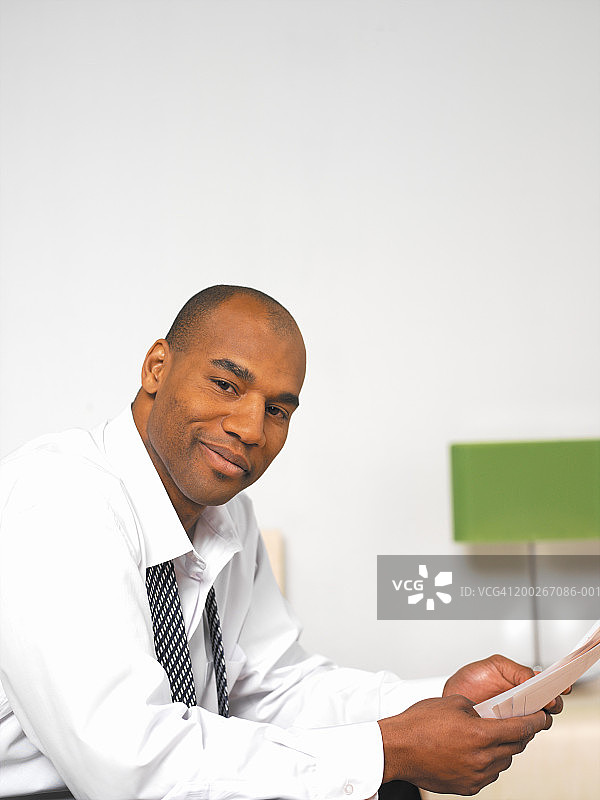 商务人士手持文件微笑侧面照图片素材