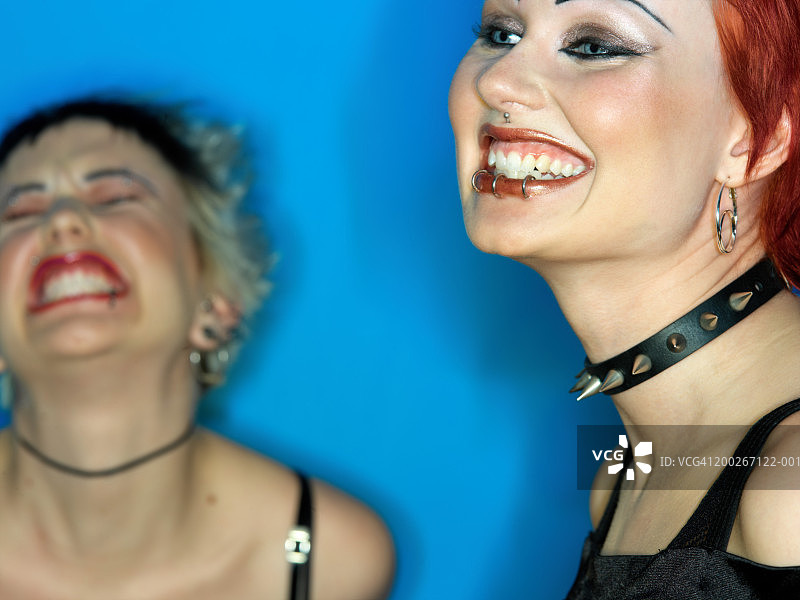 两名正在欢笑的年轻女性（焦点在前方的女性身上）图片素材