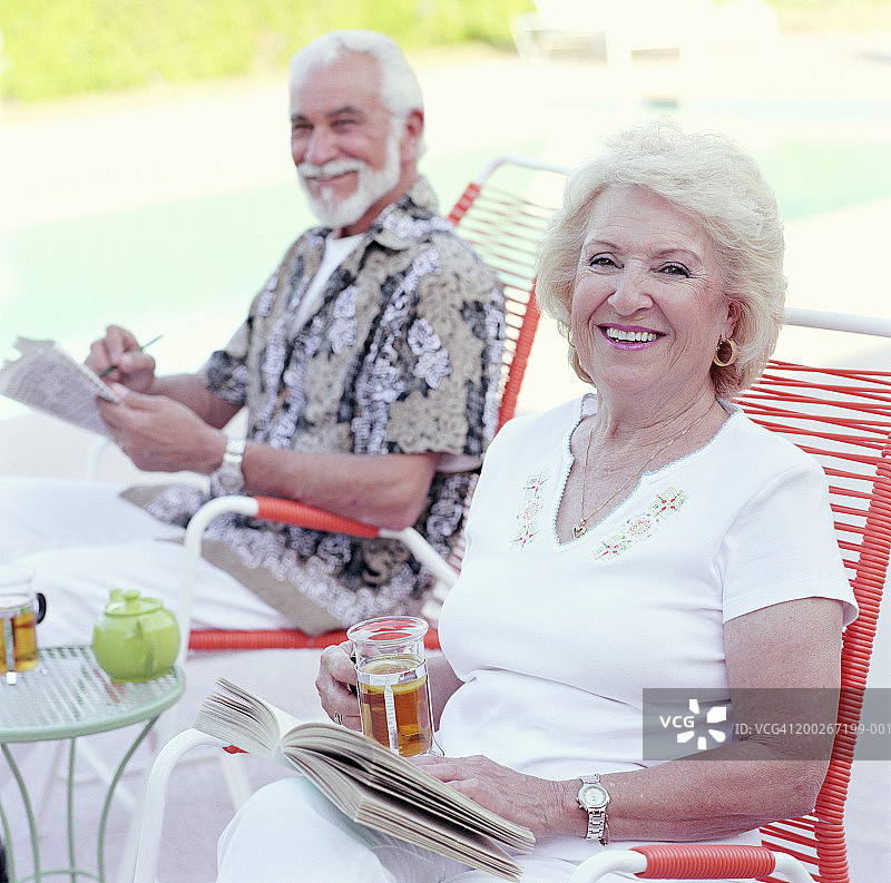 年长夫妇户外微笑合影（焦点在手持书本的女人身上）图片素材