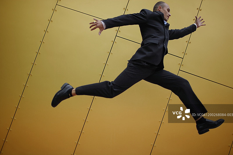 跳跃的年轻商人（侧面）图片素材