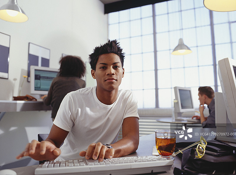 网吧里使用电脑的年轻男人肖像图片素材