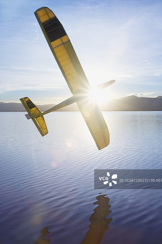 阳光下湖面上飞行的遥控滑翔机图片素材