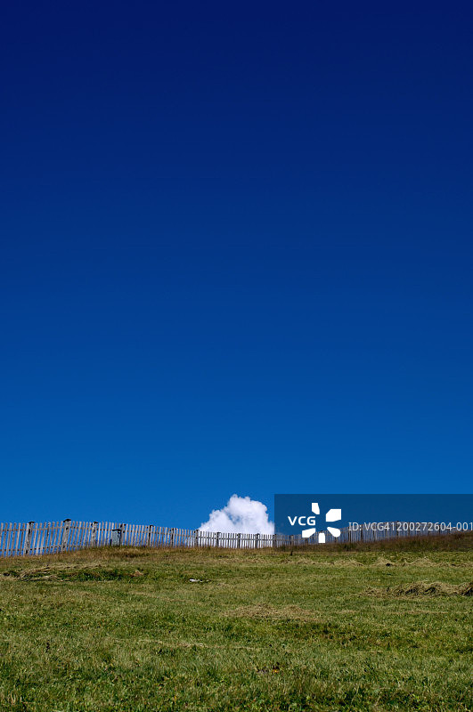 蓝天下草山上的木制栅栏图片素材