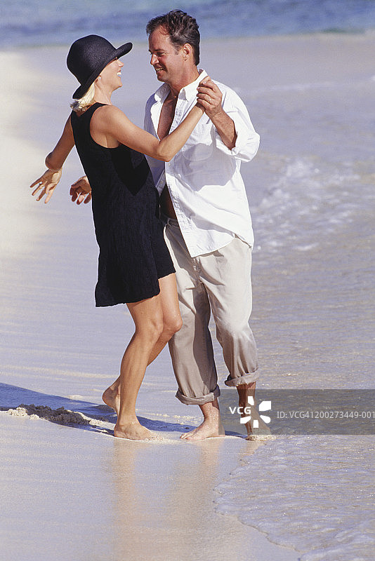 情侣在沙滩上跳舞，欢笑图片素材