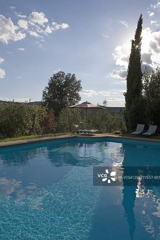 游泳池旁的日光浴床和遮阳伞图片素材