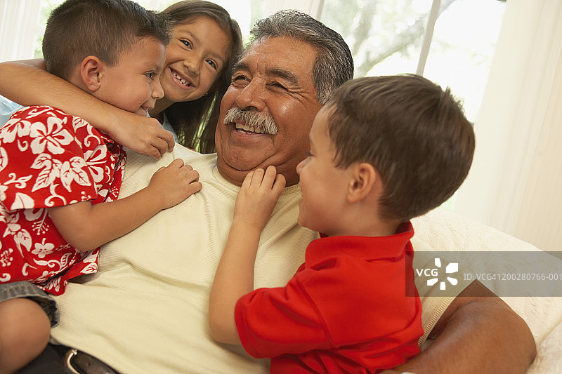 祖父拥抱孙子和孙女的特写图片素材