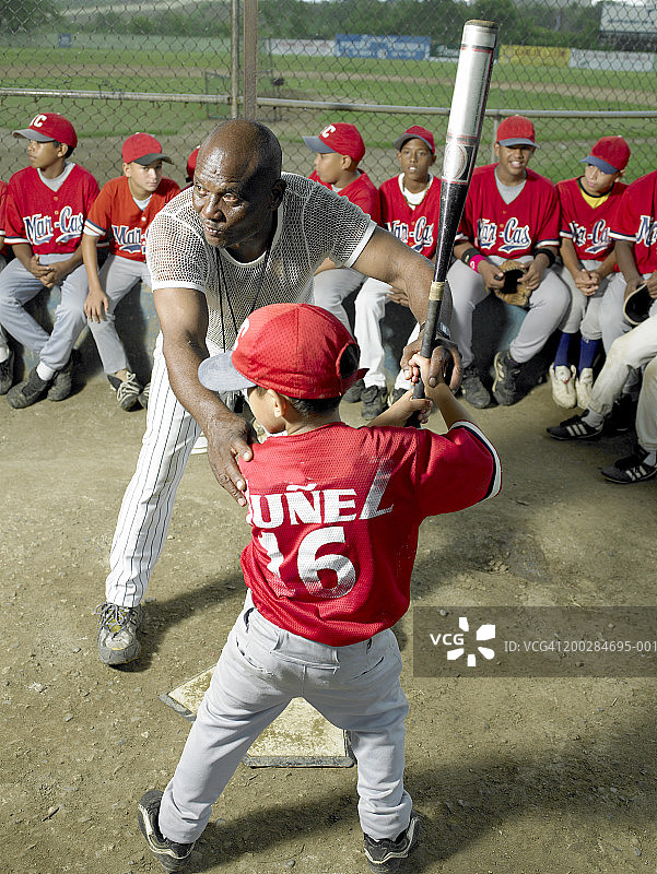 教练教男孩（9-11岁）如何击球图片素材