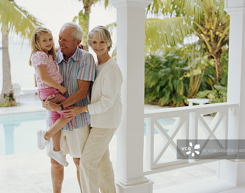 在阳台上和孙女（3-5岁）一起微笑的祖父母图片素材