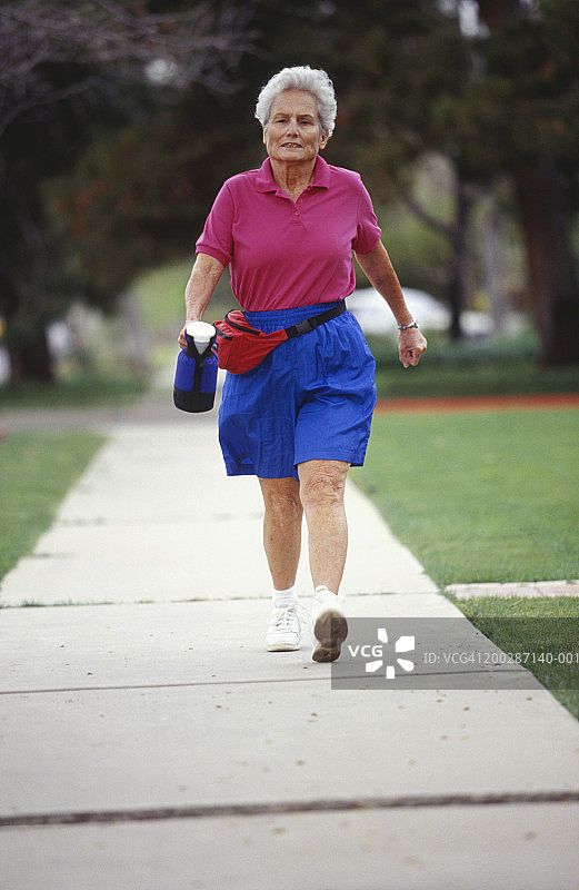 老年妇女在公园散步图片素材