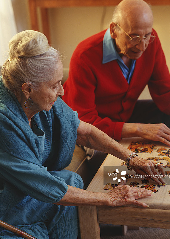 老年夫妇在客厅里拼拼图图片素材