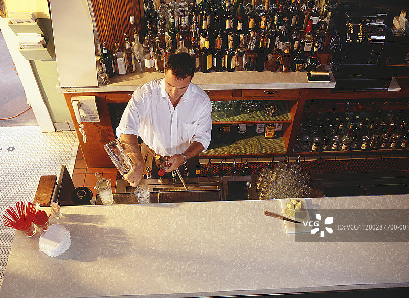酒保在吧台调制饮品，高角度视图图片素材