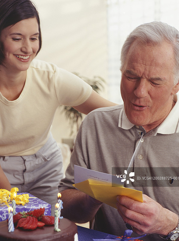 中年男人在客厅里阅读生日祝福图片素材