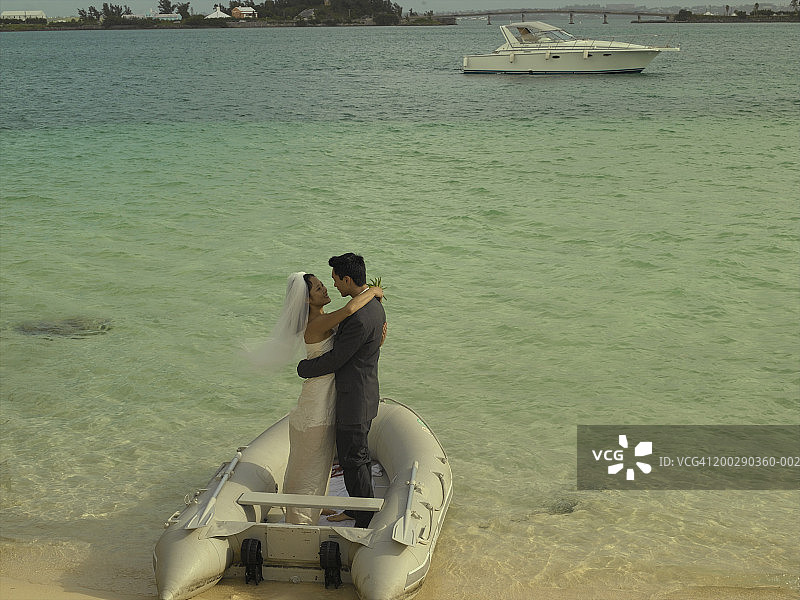 新娘和新郎在小艇中拥抱，高角度视角图片素材
