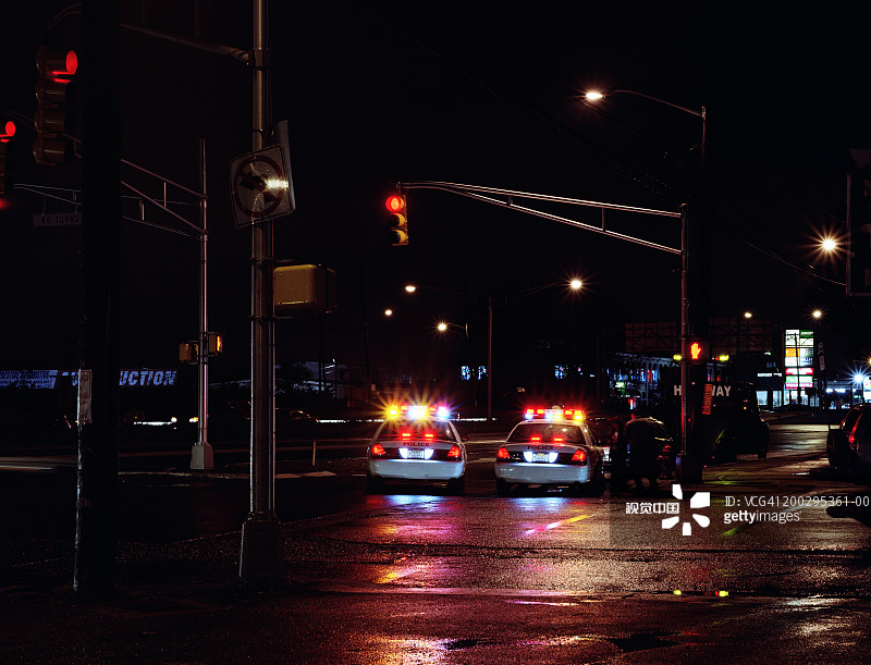 两辆警车停在高速公路上，夜晚图片素材