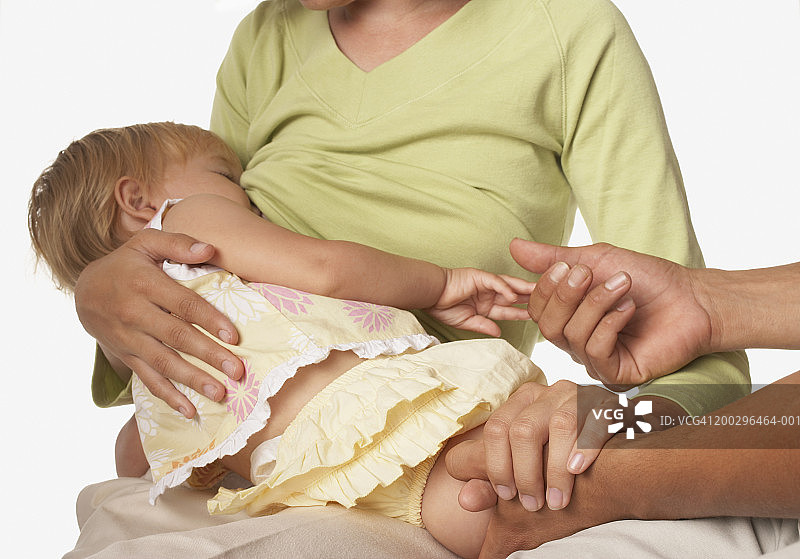 男子握着正在哺乳女婴（12-15个月）的女子之手图片素材