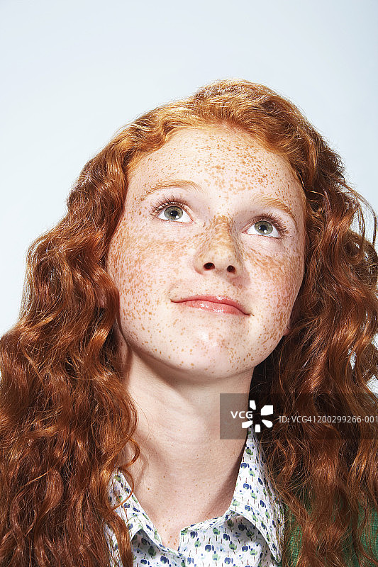 有着卷发和雀斑，向上看的少女图片素材