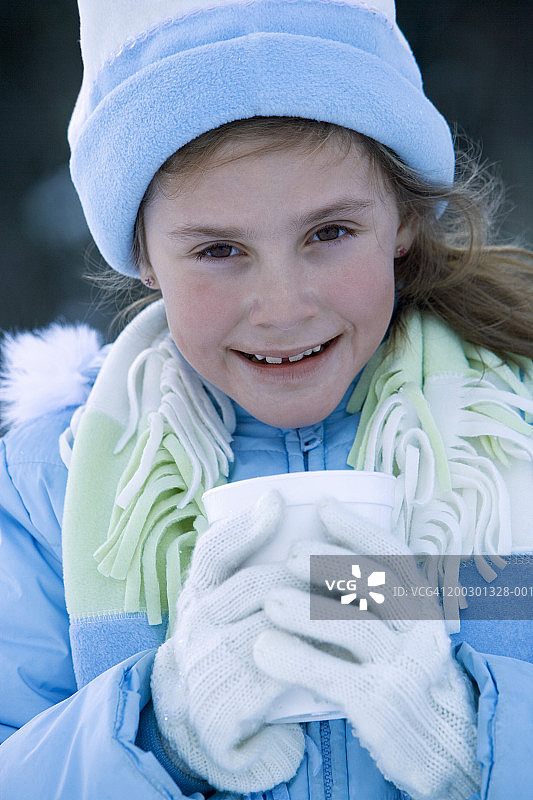 穿着冬装，拿着泡沫塑料杯的女孩（6-7岁），肖像图片素材
