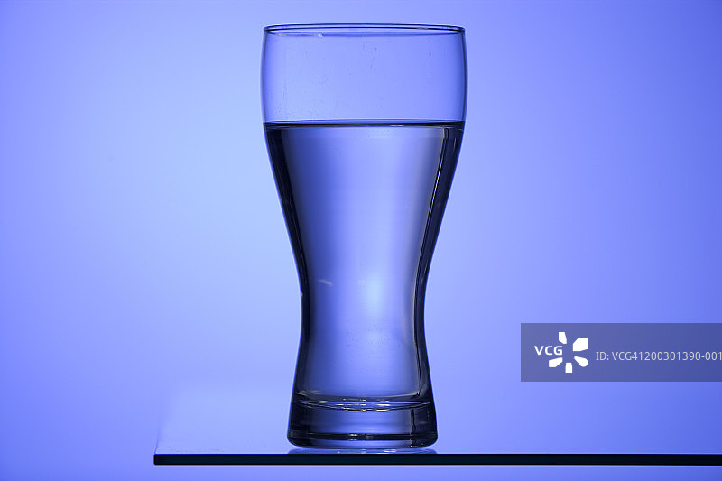 蓝色灯光下桌子上的水杯图片素材