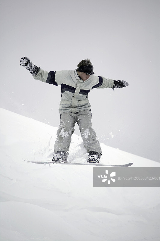 在滑雪坡上滑雪的年轻男人图片素材