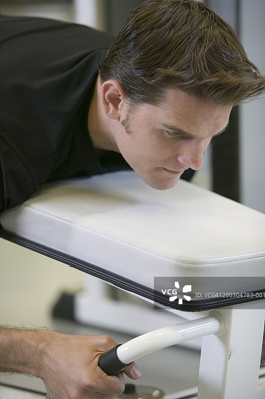 男人躺在健身房的健身椅上图片素材