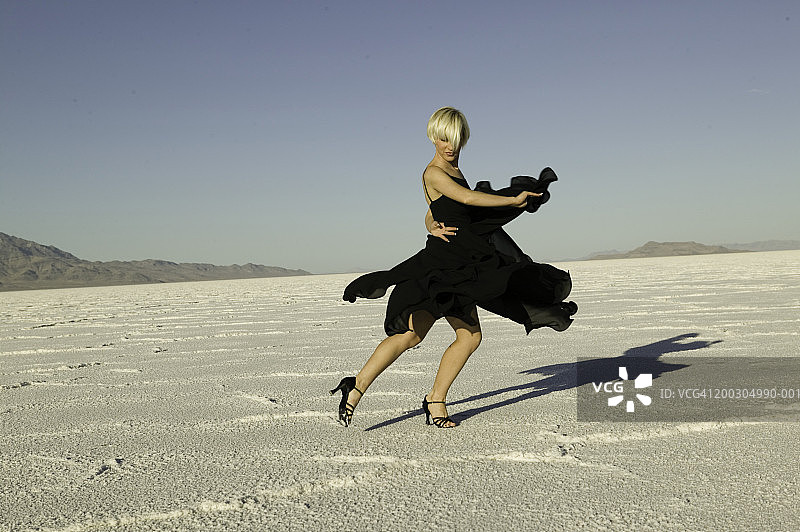 身穿弗拉门戈连衣裙，在沙漠中跳舞的女人图片素材