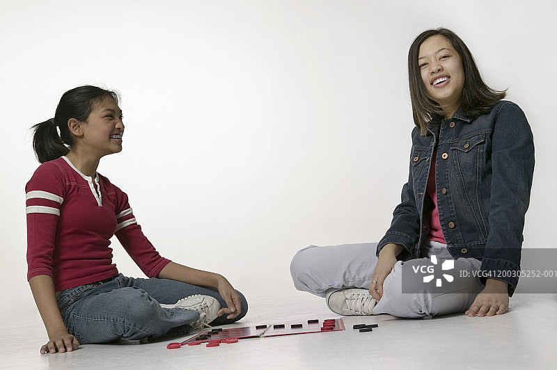 两个少女在室内玩跳棋图片素材