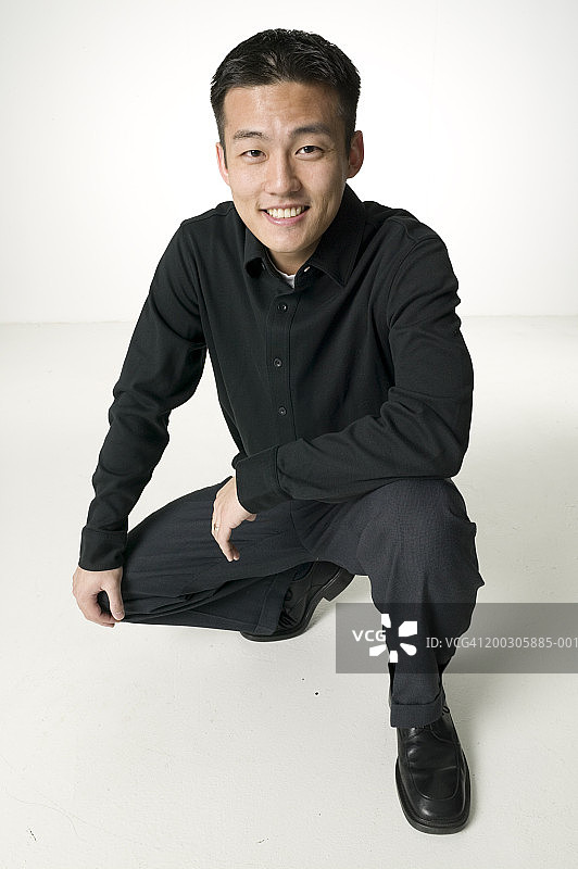在演播室中摆姿势的黑发青年人像图片素材