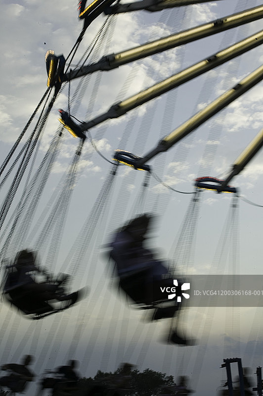 游乐园里玩旋转秋千的人，低角度拍摄图片素材