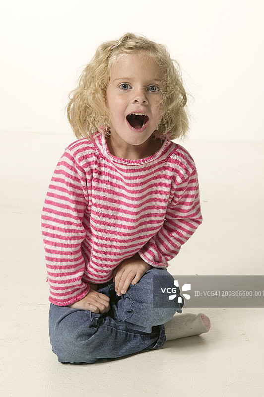 坐在地板上张着嘴的女孩（4-5岁）肖像图片素材