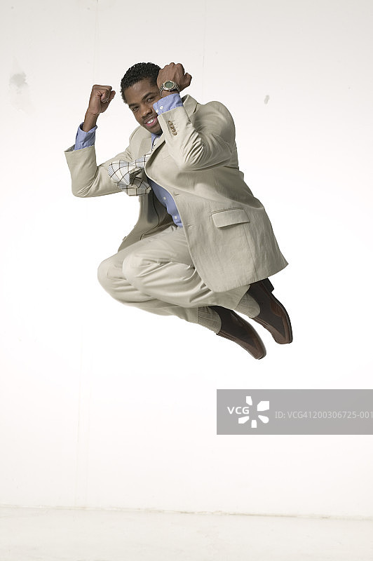 年轻的商人喜出望外地在演播室跳跃，肖像图片素材