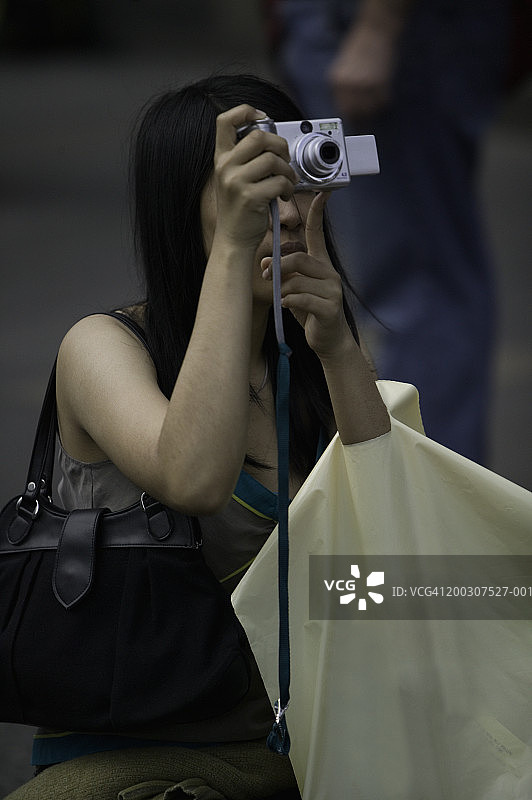 年轻女人在户外使用相机图片素材