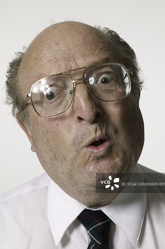 年长的男人在工作室做鬼脸，特写图片素材