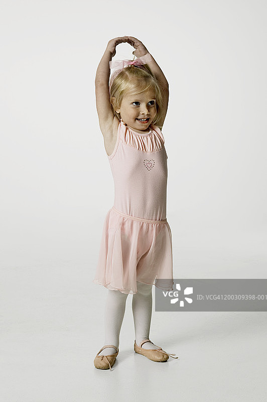 身穿粉色连衣裙的4-5岁女孩影棚人像图片素材