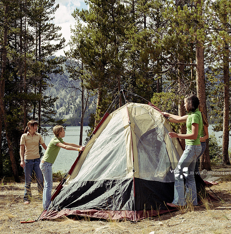 四个女孩（10-19岁）在湖边搭帐篷图片素材