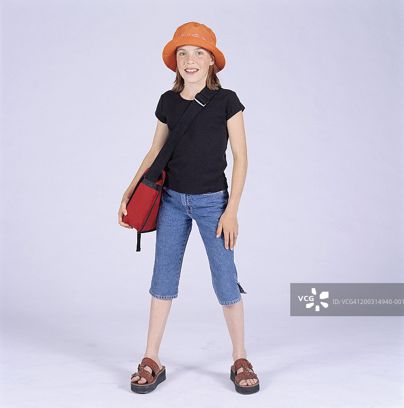 手提书包在影棚摆姿势的少女（13-14岁）肖像图片素材