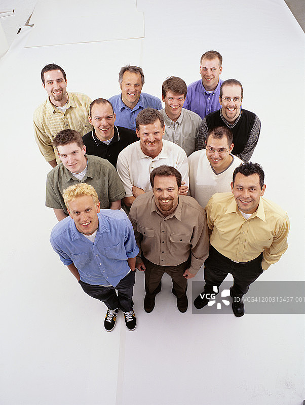 摄影棚内并排站立的大群男人肖像，高角度拍摄图片素材