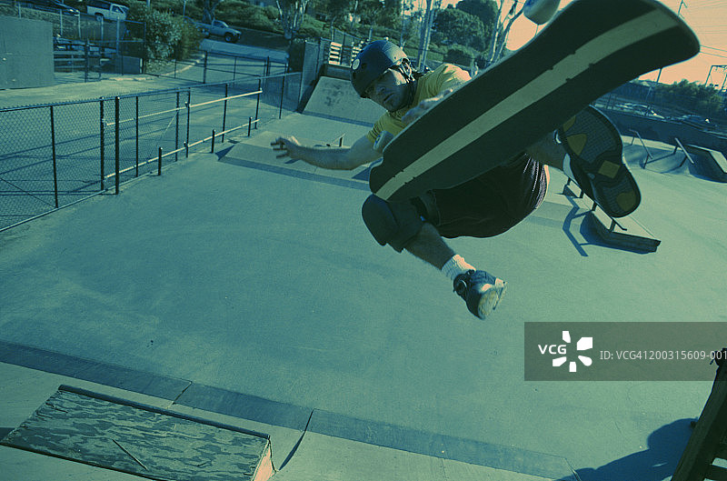 在坡道上玩滑板的年轻男人图片素材