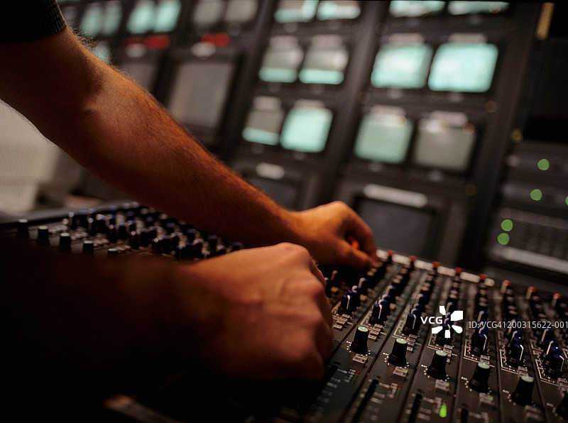 在电视台演播室的调音台旁的年轻男人，特写，表面视角图片素材