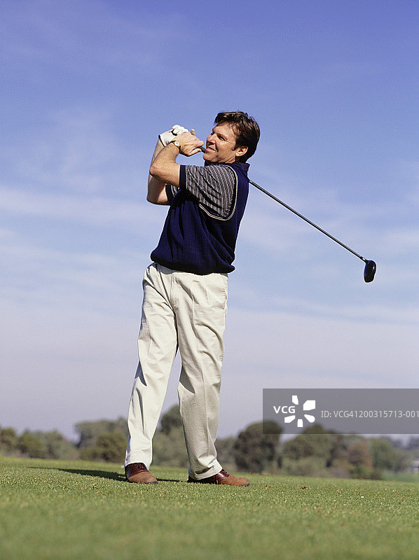 男高尔夫球手在高尔夫球场上挥杆图片素材