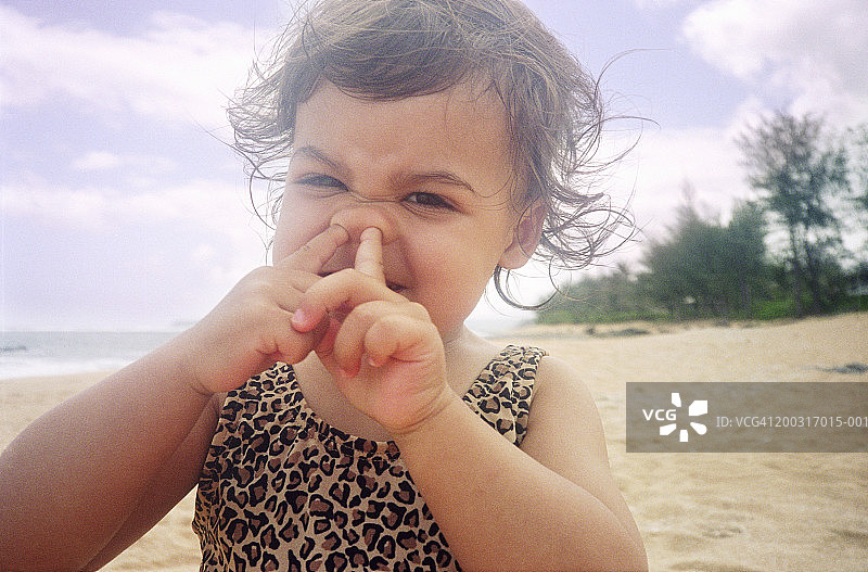 海滩上抠鼻孔的女孩（1-3岁），特写肖像图片素材