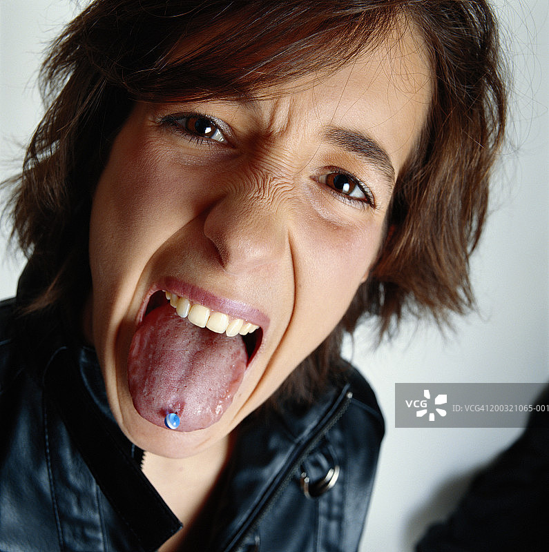 年轻男子伸出穿孔的舌头特写图片素材