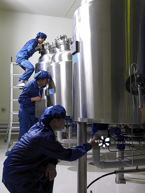 身穿防护服的工人在发酵室检查机器图片素材