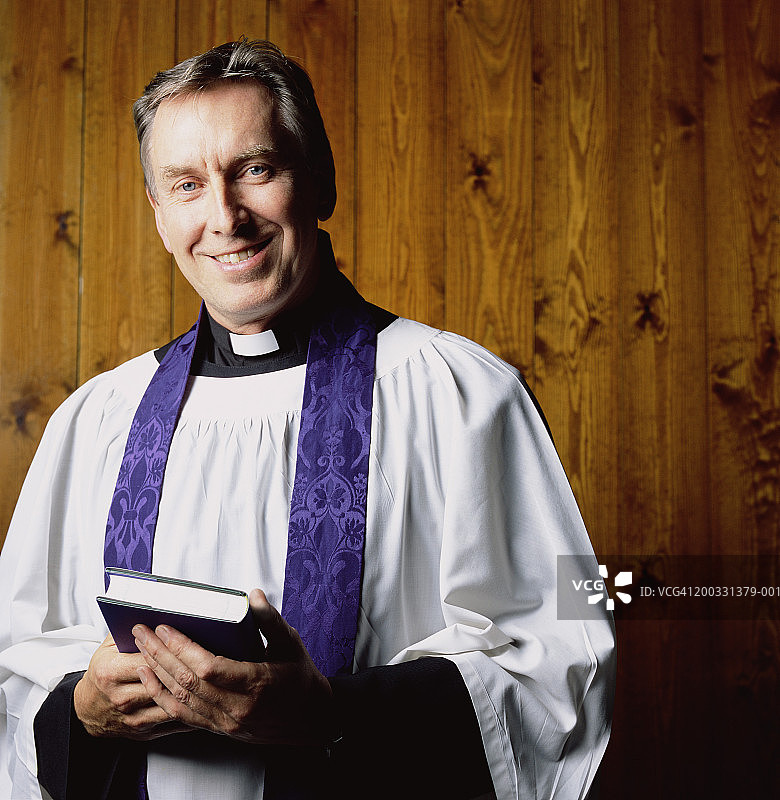 手持祈祷书的牧师肖像图片素材